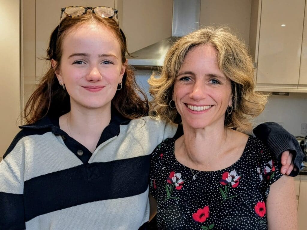 Kat with her arm around her mum Rosie, smiling at the camera