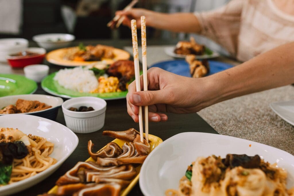 Woman using chopsticks for a Chinese cuisine
