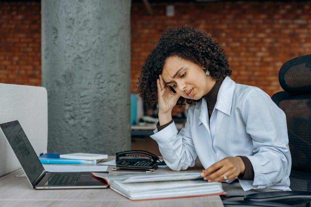 A stressed woman sat in front of her laptop.