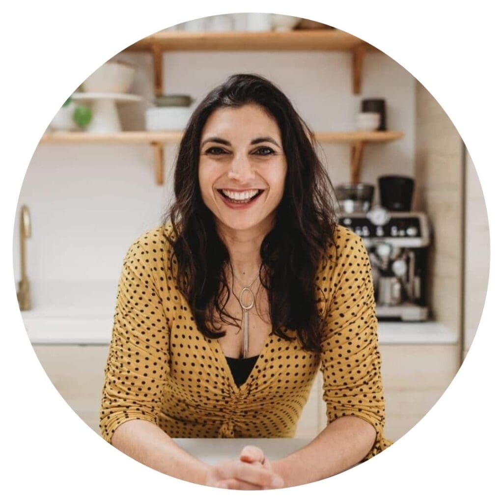 Priya Tew, smiling in a yellow top with black polka dots