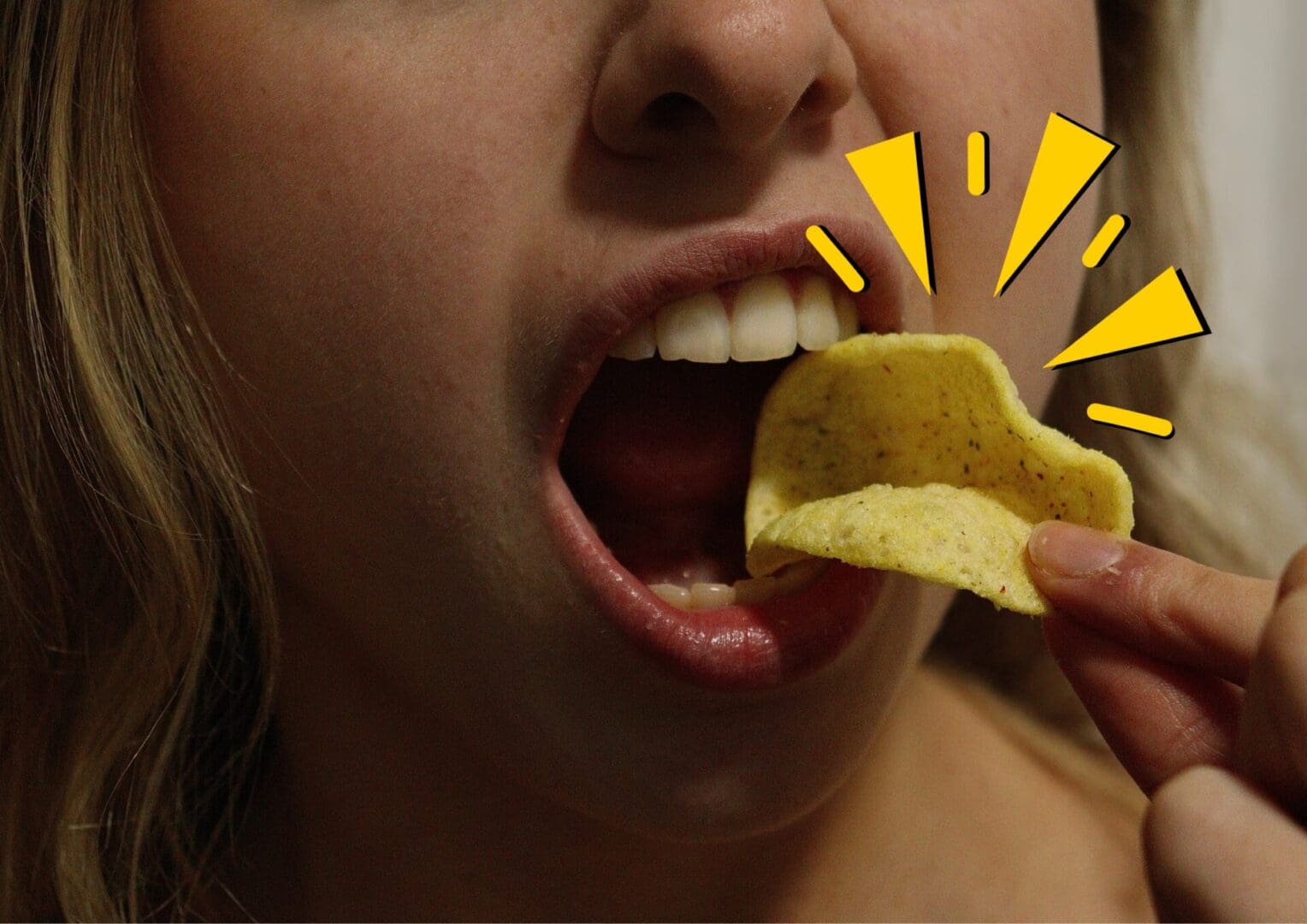 Girl crunching a small poppadom crisp with a spiky yellow graphic surrounding the crisp