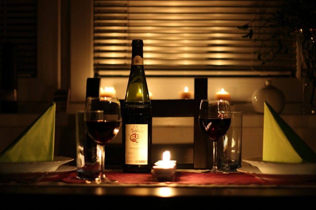 Romantic candle lit dinner with 2 glasses of red wine and a bottle