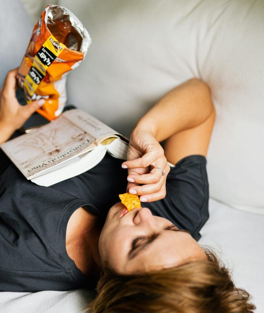 Eating crisp mm A woman is lying down eating crisps