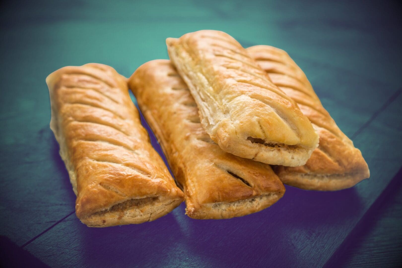 SAUSAGE ROLL A pile of four sausage rolls.