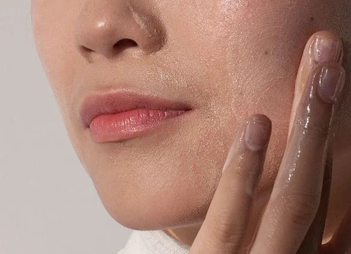 Woman rubbing a cream on her face