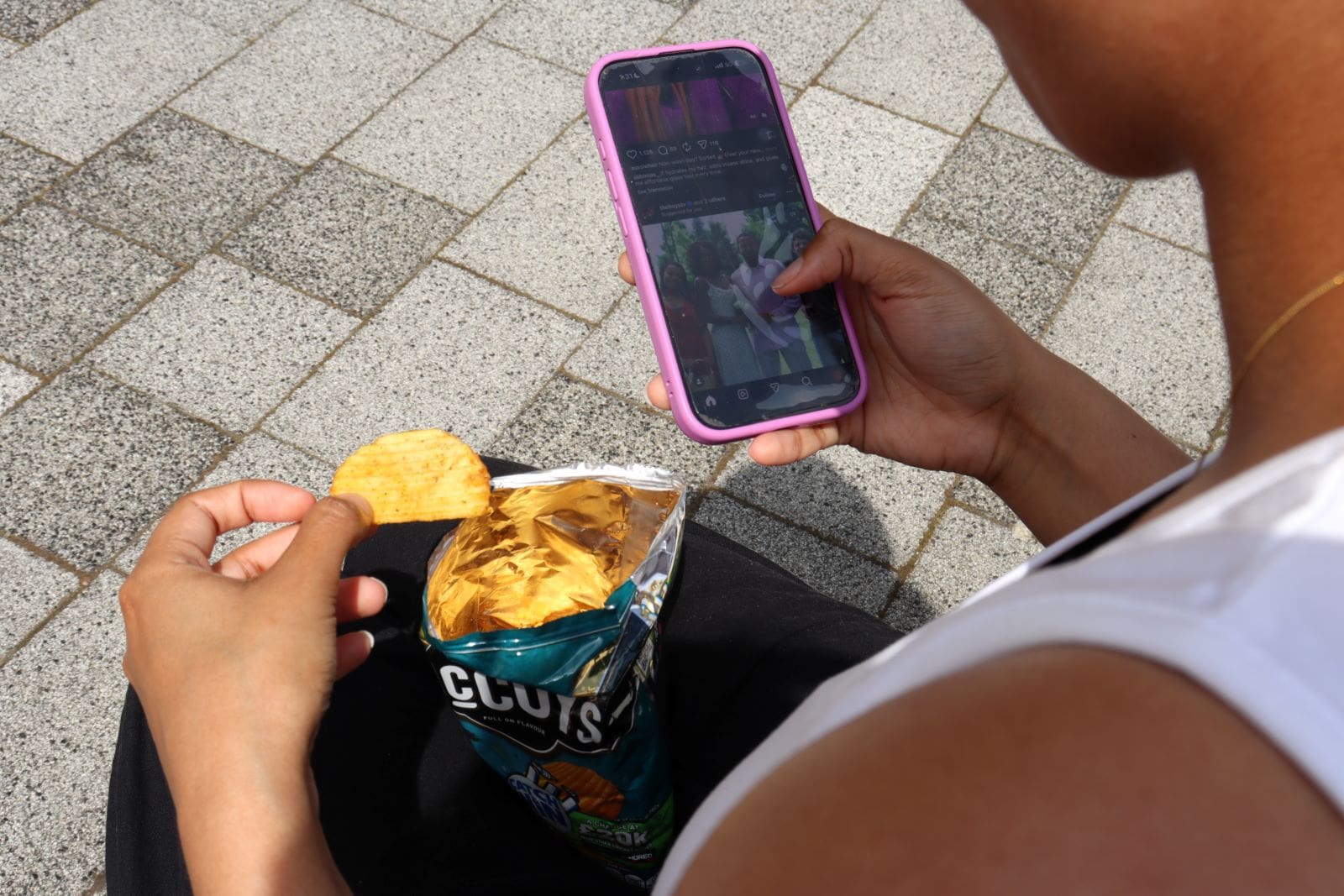 malise Girl eating crisps and scrolling on her phone