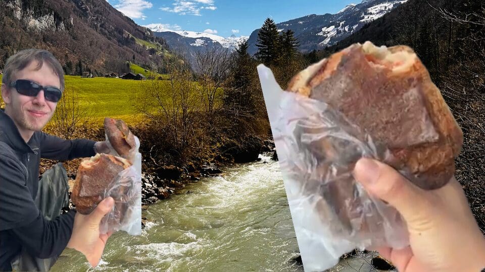 Picture of a hiker eating a sandwich with a beautiful view.