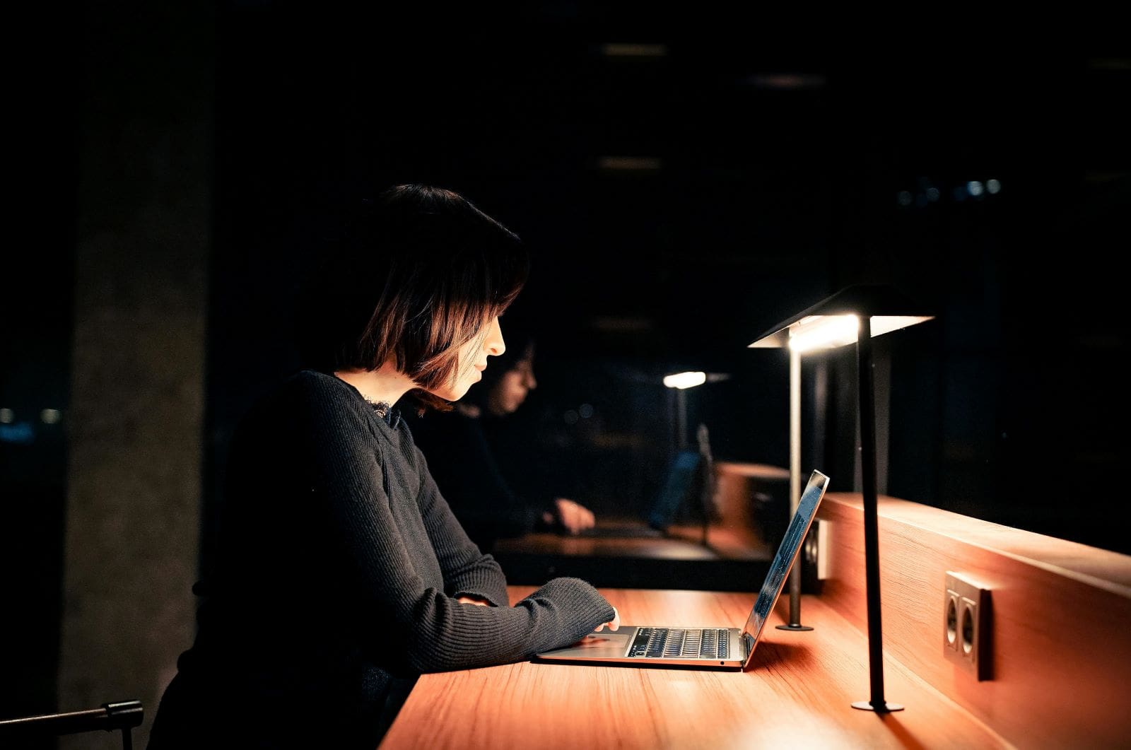 Woman focused on laptop late at night