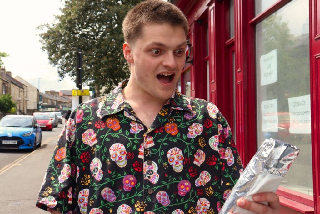 Man looking happy with his food that he's about to eat.