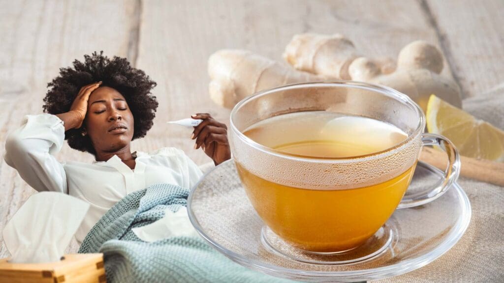 Picture of a women with one hand holding her head, and holding a digital thermometers. On the right side of the picture, there is a cup of ginger tea, with slice of lemon and fresh ginger in the background.